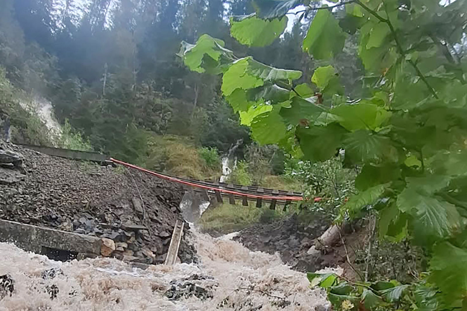 En flomstor bekk har vasket vekk fyllinga slik at sporet henger i løse lufta i 12-15 meter.