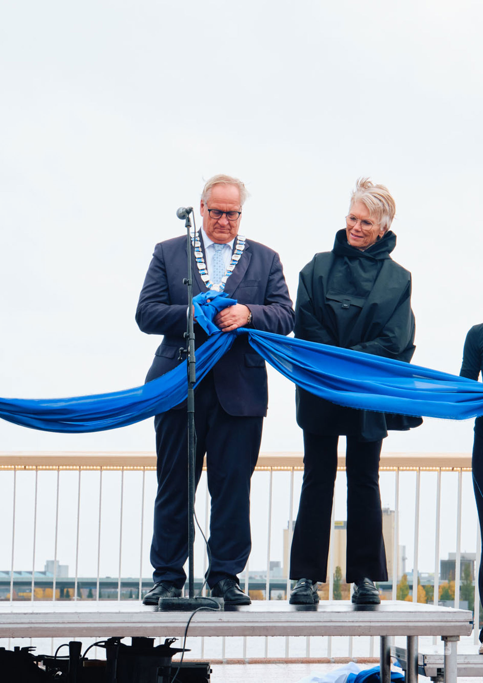Ordføreren knytter bånd sammen for å symbolsk markere at de to sidene av elven igjen er forbundet.