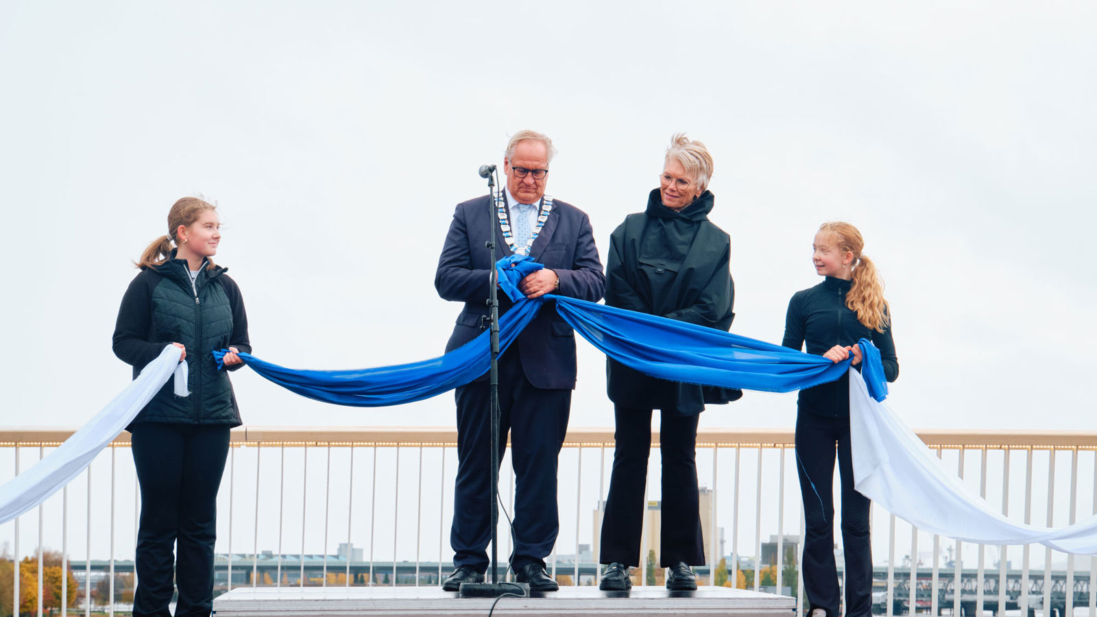 Ordføreren knytter bånd sammen for å symbolsk markere at de to sidene av elven igjen er forbundet.