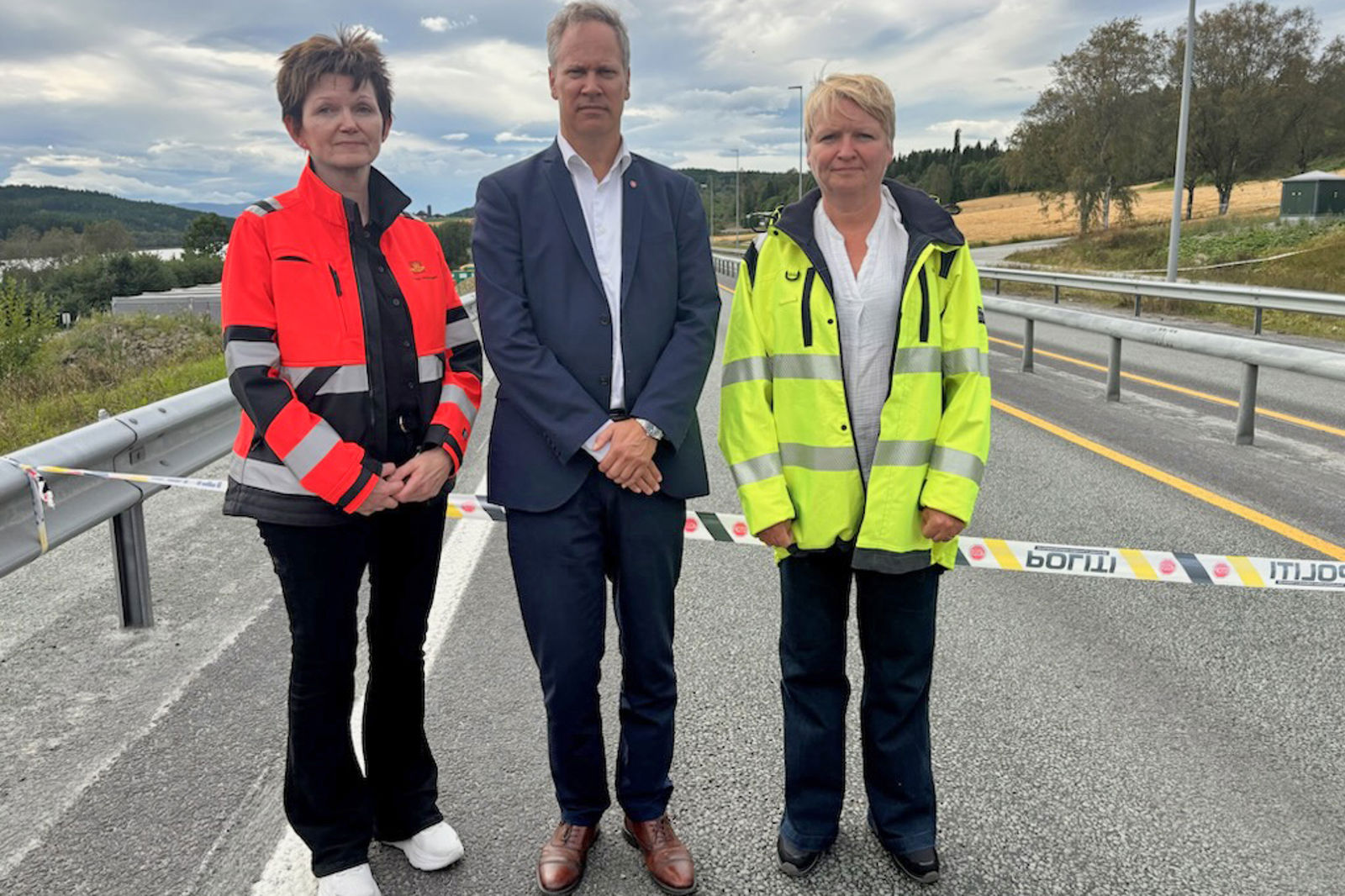 De tre er fotografert foran politisperringen på E6.