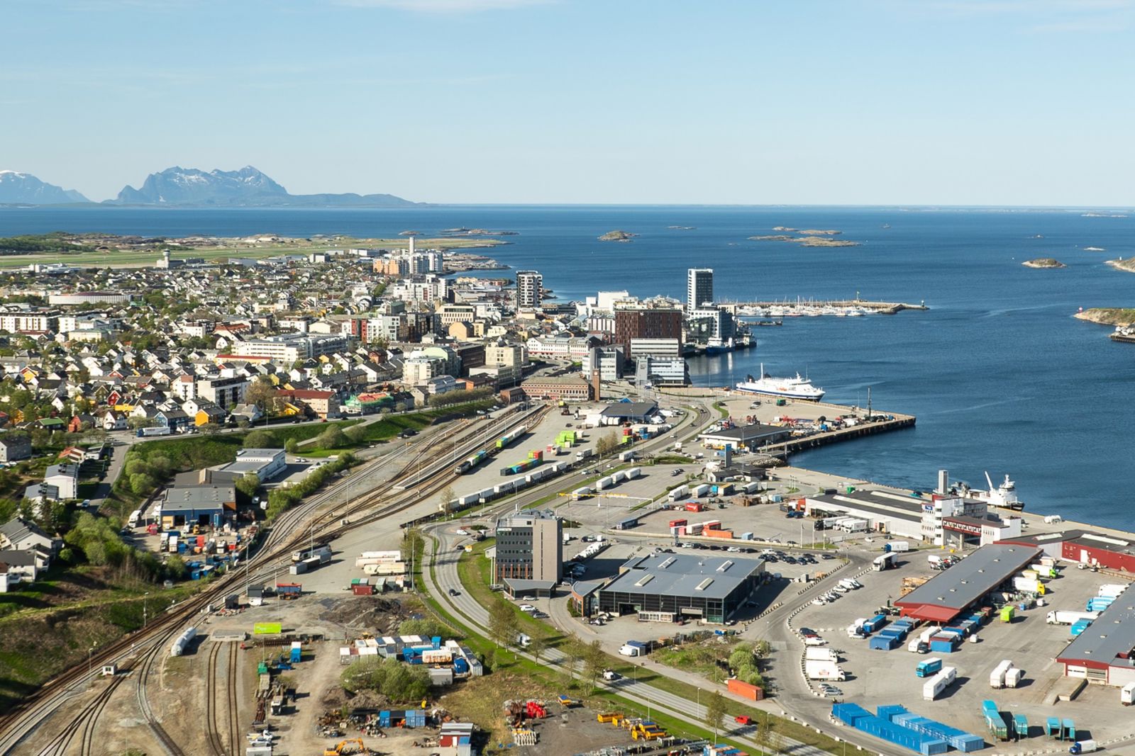Dronebilde som viser Bodø stasjon og Bodø havn med havet i bakgrunn.