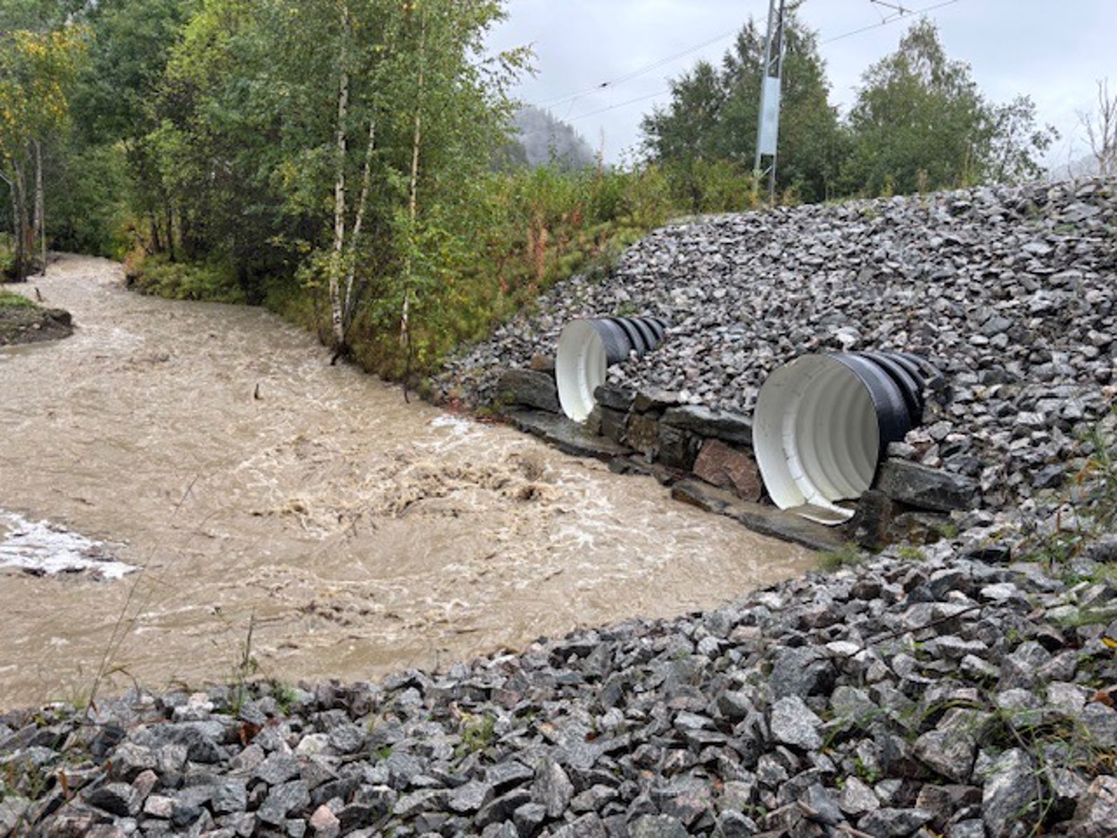 Vannet renner gjennom to rør under jernbanen.
