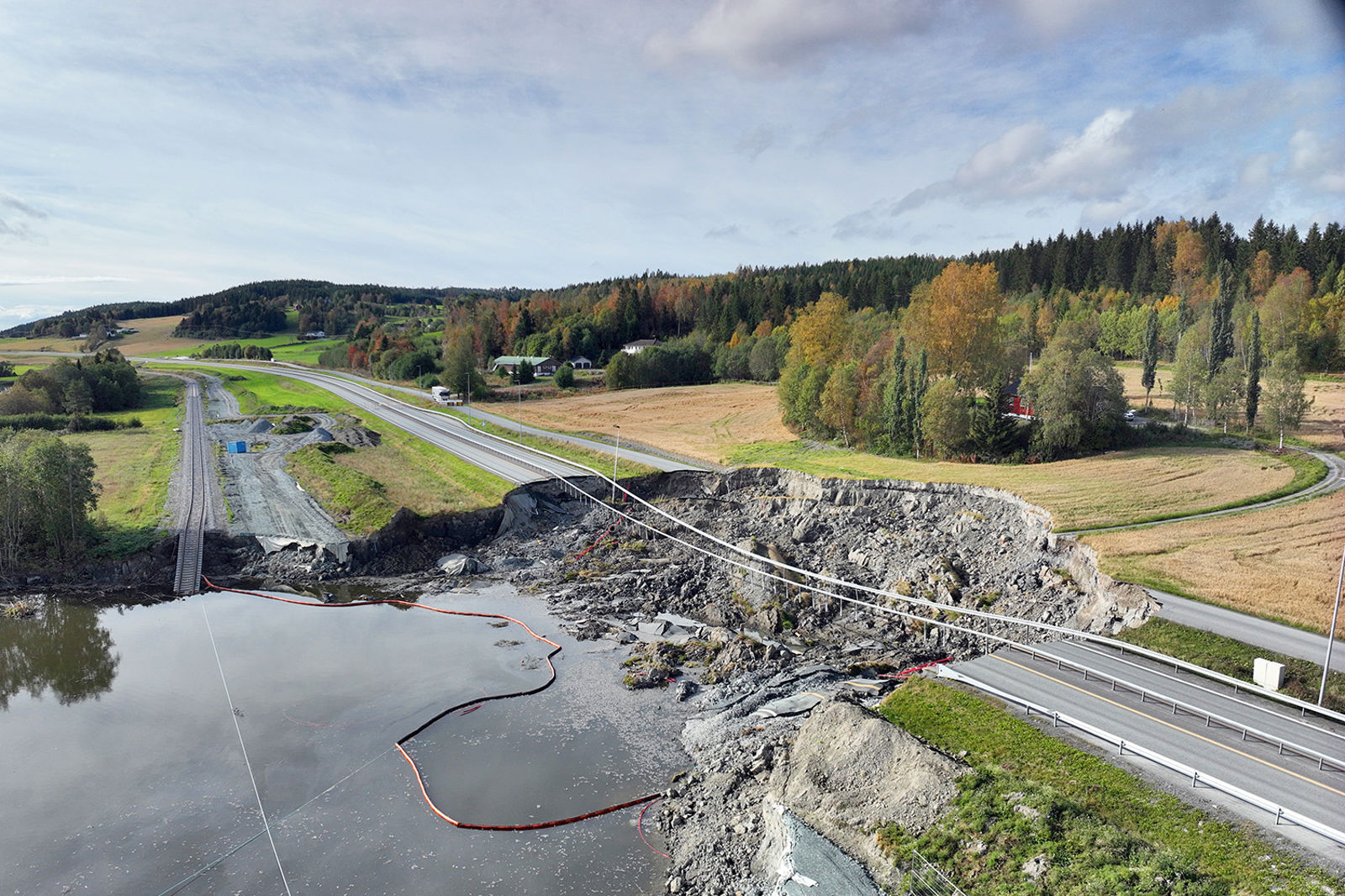 Nesvatnet i forgrunnen, jernbane og europaveg er brutt av av rasgropa.
