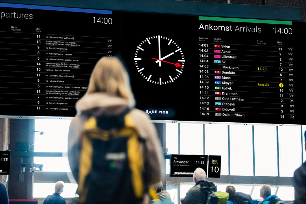 Bildet av en unk jente som ser på monitoren over avganger og ankomster på Oslo S.